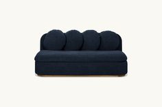 a blue couch with four pillows on it's back and the seat upholstered