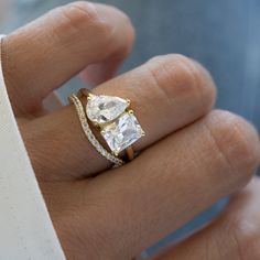 a woman's hand with a ring on it and a diamond in the middle