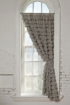 an open window with a curtain hanging from it's side