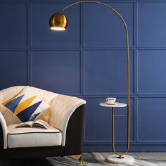 a living room with blue walls and a white chair next to a gold floor lamp