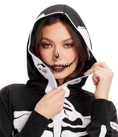 a woman wearing a black and white hoodie with the skeleton face paint on it