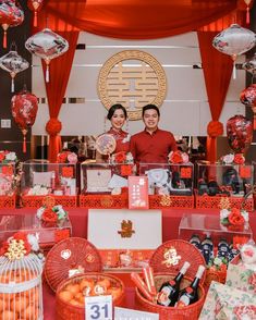 two people standing in front of a table with decorations