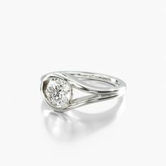 a white gold ring with a round diamond in the center, on a white background