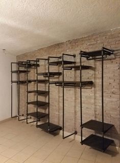 an empty room with shelves and shelving in the corner, all lined up against a brick wall