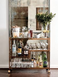 a bar cart filled with lots of bottles and glasses