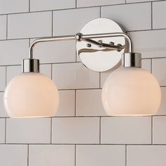 two light fixtures mounted on a white tiled wall