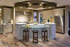 a large kitchen with an island in the middle and two stools at the center