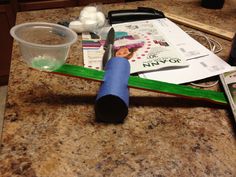 a knife and other items on a counter top next to a plastic cup with water in it