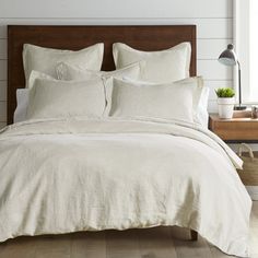 a bed with white linens and pillows in a bedroom