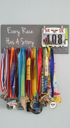 there are many medals hanging on the wall next to a sign that says every race has a story