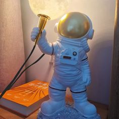 an astronaut statue holding a lamp in his hand