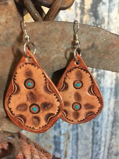 "Stamped leather earrings. Each earring is stamped by hand then hand painted with turquoise and bronze accents. This set is bold as well as lightweight. Leather piece approx: 2\" x 1.25\" Tag us on Instagram @doubleAconnected to be featured! All items produced by Double A Connected Leatherworks are handmade, many to-order. In working with leather there will be slight variations from item to item--these are not flaws. These are truly one of a kind, handmade items not produced on a large scale." Bohemian Hand-tooled Leather Earrings, Bohemian Turquoise Leather Earrings, Bohemian Hand-tooled Drop Earrings, Artisan Brown Hand Tooled Earrings, Hand Tooled Teardrop Bohemian Earrings, Handmade Southwestern Leather Earrings, Bohemian Hand Tooled Teardrop Earrings, Handmade Leather Turquoise Earrings, Handmade Leather Earrings In Turquoise