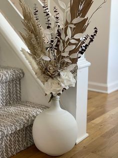 there is a vase with flowers in it on the stairs