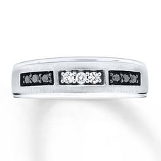 a white gold ring with black and white diamonds