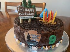 a birthday cake with candles on it sitting on a table