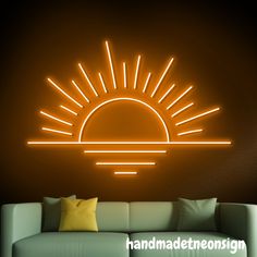 a living room with a couch and a neon sun wall decal