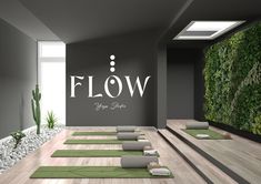 yoga mats lined up in front of a wall with the words flow on it and succulent plants