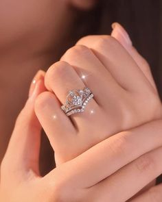 a close up of a person's hand holding a diamond ring