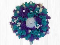 a purple and green wreath with white flowers