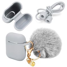 an airpods with a fur ball attached to it and two earphones next to it