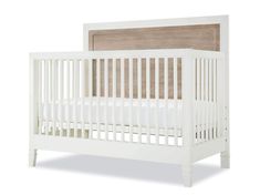 a white crib with a wooden headboard