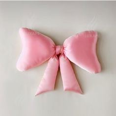 a pink bow pillow on a white surface