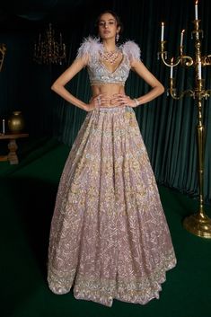 Step into refined elegance with this enchanting lehenga set, inspired by the undertones of the dawn sky, where pink, blue, and glimmering stars come to life. Crafted from delicate net, it features radiating sequins in gold, blue, and pink, beautifully accentuated by resham work. The intricate detailing mirrors the stars, ensuring that every movement radiates brilliance. The blouse showcases a modern reverie with feather detailing, perfectly complemented by a net dupatta adorned with a graceful b Pink Zari Work Skirt Set For Party, Glamorous Lehenga With Unstitched Blouse For Diwali, Glamorous Sets With Zari Work For Eid, Glamorous Semi-stitched Lehenga For Eid, Glamorous Designer Lehenga For Eid, Glamorous Fitted Lehenga For Eid, Glamorous Semi-stitched Lehenga For Diwali, Glamorous Resham Embroidery Lehenga For Eid, Glamorous Pink Dress With Zari Work