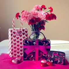 pink flowers and gift bags on a table