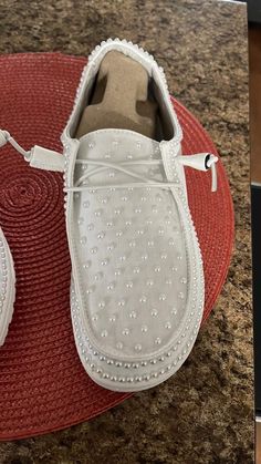 a pair of white shoes sitting on top of a red mat