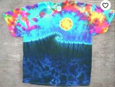 a t - shirt with an image of the sun and mountains in tie dye on it