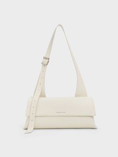 This product is made with at least 20% sustainable materials by weight. CHARLES & KEITH uses recycled, degradable, organic, and water-based materials in our eco-conscious collection. A polished bag in chic cream is the perfect accessory for summer and beyond. With an elongated trapeze silhouette and an elongated shoulder handle -- which can be adjusted to suit your preferred drop length -- this clean and sleek design will complement any outfit of your choice, from flowy dresses to casual denim looks. Fitted with a magnetic closure, it opens up to an spacious inner compartment -- thanks to the the horizontal silhouette of this bag, it will easily hold your daily essentials and then some. Trapeze Silhouette, Trapeze Bag, Flowy Dresses, Latest Bags, Pretty Bags, Charles Keith, Daily Essentials, Eco Conscious, Casual Denim