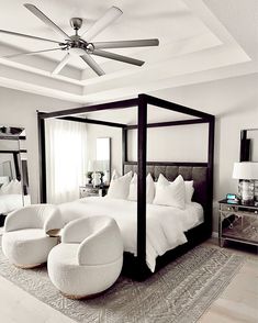 a bedroom with a four poster bed and white furniture