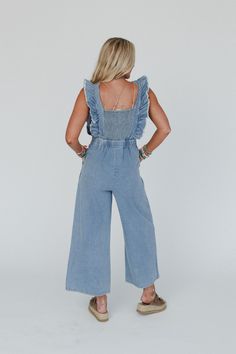 You're going to love the Tiffany Ruffled Denim Jumpsuit. Whether you're running errands or catching up with friends, these overalls will keep you stylish and confident all day long! Comfortable, Cotton denim fabric Relaxed jumpsuit silhouette at ankle length Flattering square neckline and tank straps with exaggerated ruffle trim Pleated details along the bodice, side zipper closure and elastic square smocked panel along the back Gathered center seam at waist line creating beautiful pleating Loos Catching Up With Friends, Boho Essentials, Bralette Outfit, Comfy Pants, Denim Jumpsuit, New Tops, Denim Fabric, Ruffle Trim, Square Neckline