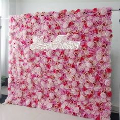 a pink flower wall with the word wedding flowers written on it