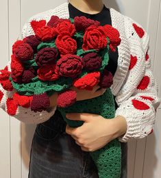 a woman holding a bouquet of crocheted roses