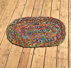 a multicolored rug sitting on top of a wooden floor next to a black cat