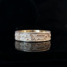 Crafted with meticulous attention to detail, this ring boasts a design adorned with captivating hieroglyphics that whisper tales of mystique and power. At its core lies a profound message, engraved in the ancient language of the pharaohs: "I am one of those shining beings of light." These words, laden with significance, echo the timeless quest for enlightenment and the divine within. The sleek and polished surface of the ring serves as the perfect canvas for the intricate hieroglyphics. Look clo Symbolic Yellow Gold Engraved Ring With Intaglio, Spiritual 14k Gold Engraved Wedding Ring, 14k Gold Spiritual Engraved Wedding Ring, 14k Gold Engraved Spiritual Wedding Ring, Symbolic Carved Jewelry For Formal Occasions, Symbolic Intaglio Engraved Ring, Yellow Gold Symbolic Carved Jewelry, Carved Symbolic Yellow Gold Jewelry, Symbolic Engraved Rings For Ceremonial Occasion