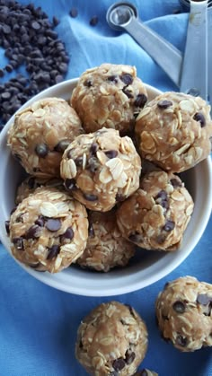 a white bowl filled with oatmeal chocolate chip energy bites on top of a blue cloth