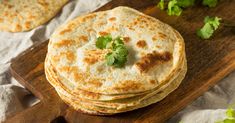 three tortillas on a cutting board with cilantro