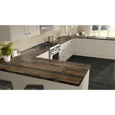 a kitchen with an island counter top next to a stove and sink in the center