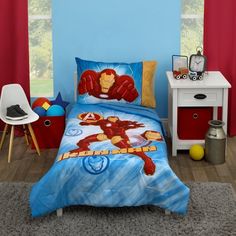 a bedroom with blue walls and a bed covered in an iron man comforter set