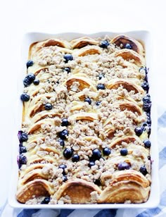 a casserole dish with blueberries and crumbled toppings on top