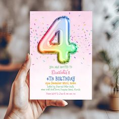 a person holding up a birthday card with the number four on it