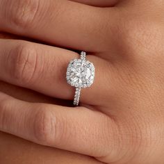 a woman's hand with a diamond ring on top of her finger and an engagement band