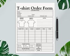 a t - shirt order form on top of a table next to some green leaves