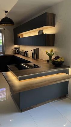 a modern kitchen with an island countertop and built - in lighting above the sink