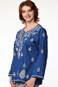 Our Saheli Embroidered Tunic is hand embroidered by women artisans in Uttar Pradesh, India. The embroidery motifs are first block-printed onto the garment and then the women do the embroidery in their homes, which allows them to do the work on their own schedule between other household work. Our soft embroidered cotton tunic tops feature fine embroidery on the front and back and are designed for a comfortable, elegant fit. Available in two sizes, S/M and L/XL. Spring Embroidered Straight Kurta Fabric, Multicolor Embroidered Folk Fabric, Festival Embroidered Multicolor Top, Intricate Embroidery Cotton Fabric, Festive Embroidered Fabric With Embroidered Border, Long Sleeve Blouse With Motif, Bohemian Chikankari Embroidered Fabric, Traditional Blue Blouse With Chikankari Embroidery, Festival Chikankari Embroidered Top