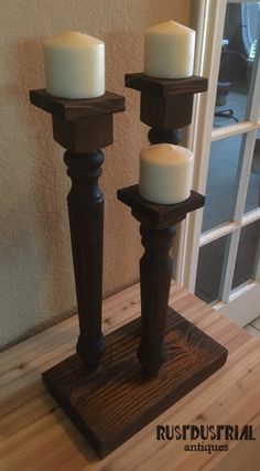 three candles are sitting on a wooden stand