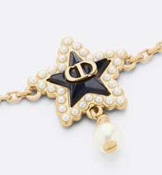 The Petit CD Lucky Baroque bracelet is a modern take on the House's codes of refinement. Crafted in gold-finish metal, it features Mr. Dior's CD signature star in deep ocean blue glass delicately surrounded by small white resin pearls, from which a pearl is suspended. The elegant, sophisticated bracelet is ideal for pairing with other creations from the Petit CD Lucky Baroque line..