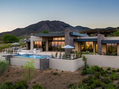 a house with a swimming pool in the front yard and mountains in the back ground